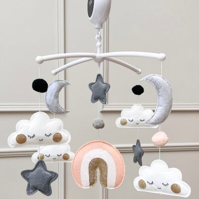 Muziekmobiel met roze regenboog van vilt – witte houder met wolkjes, maantjes, sterretjes en druppels van goud – handgemaakt ontwerp van Kiekepiep
